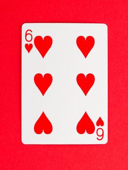 Old playing card (six) isolated on a red background