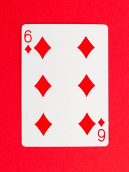 Old playing card (six) isolated on a red background