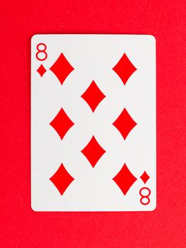 Old playing card (eight) isolated on a red background