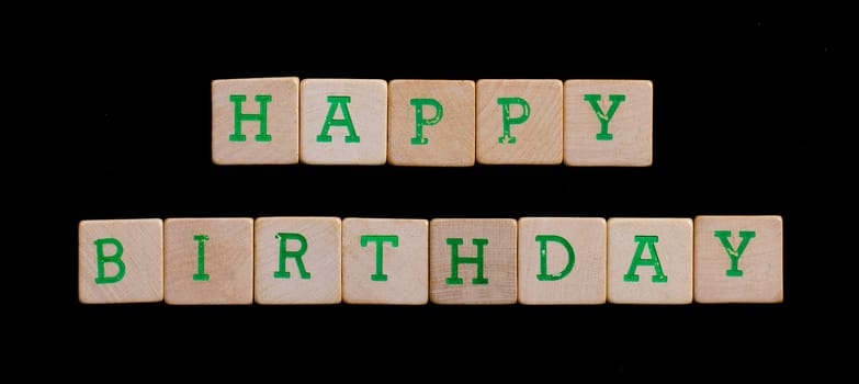 Green letters on old wooden blocks (happy birthday)