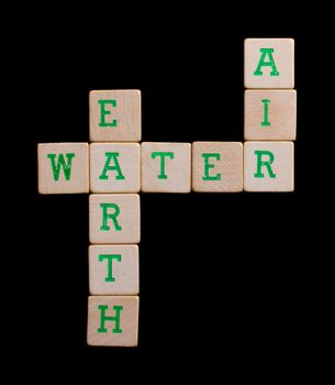 Green letters on old wooden blocks (earth, water, air)