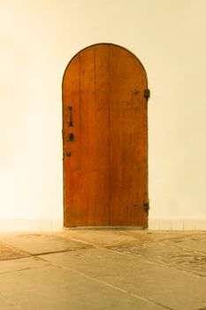 Old wooden door in a white wall
