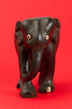 Very old ivory statue of an elephant isolated on a red beckground