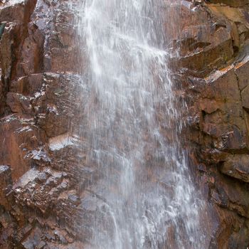 Closeup of a waterfall against a granite background