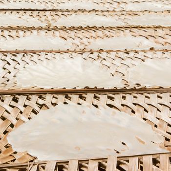 Rice paper drying at a bamboo frame , Vietnam