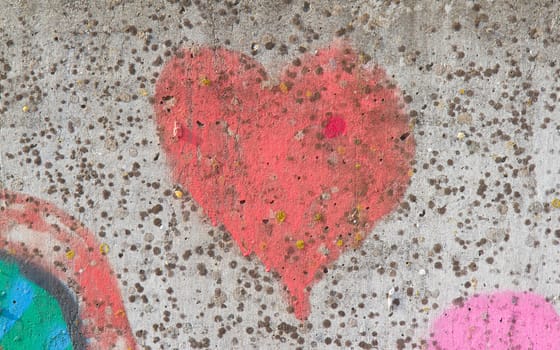 Red heart graffiti over grunge cement wall