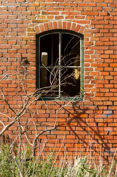 Broken window in an old brick wall