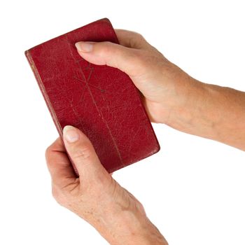 Old hands (woman) holding a very old bible, isolated on white