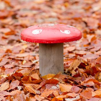 Large metal mushroom standing in a field of leaves