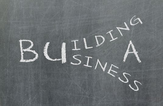 Building a business written on a chalkboard, isolated