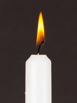 White candle isolated against a black background