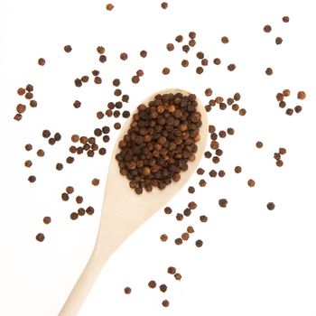 Black pepper on a wooden spoon (white background)