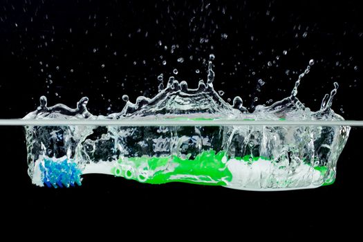 Toothbrush with splashing water on a black background