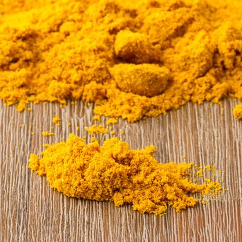 Heap of turmeric on isolated wood background