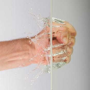 Hand (fist) with splashing water on a white background