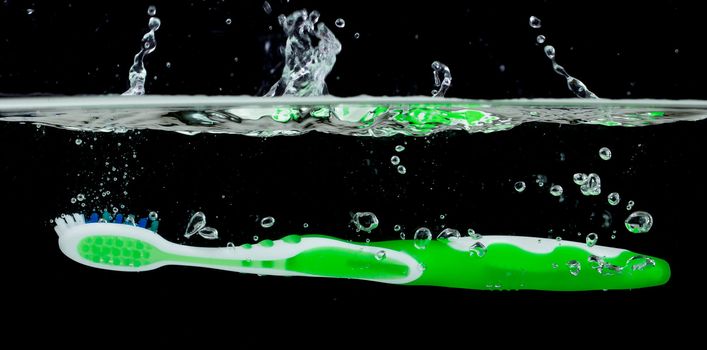 Toothbrush with splashing water on a black background