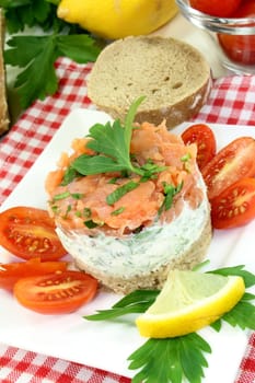 a slice of bread with herb cream and salmon tartare