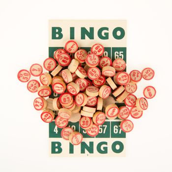 Wooden numbers used for bingo, on top of a bingo card