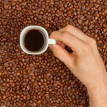 Cup of coffee on aromatic coffee beans. top view