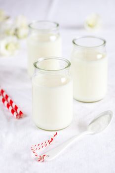 Three milk jars with white spoon