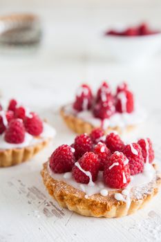 raspberry frangipane tarts with icing drizzled over the top