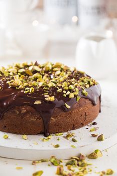 Dark chocolate cake with cardamom and covered with pistache and chocolate ganache