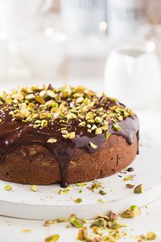 Dark chocolate cake with cardamom and covered with pistache and chocolate ganache