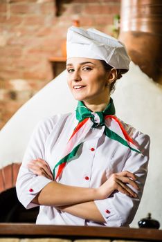 portrait of a cook, is on the traditional kitchen, crossed her arms