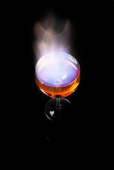 Burning alcohol poured into translucent wine glass