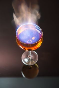 Burning alcohol poured into translucent wine glass