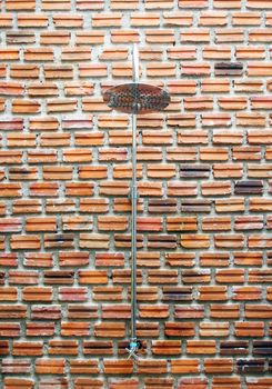 Outside shower on brick wall background