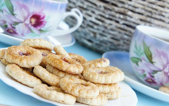 Tea porcelain cups and biscuits with marmalade         