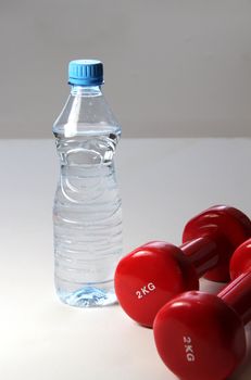Red dumbbells and bottle of water