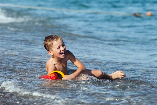 Summer vacations - little smiling child boy playing on sea sand beach