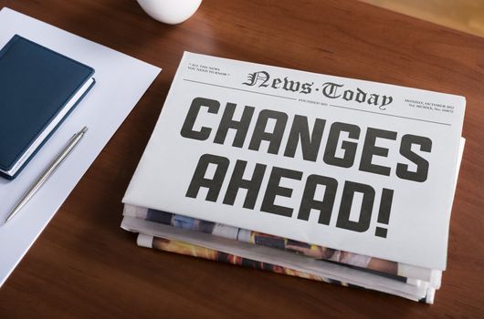 Newspaper with hot topic "Changes Ahead" lying on office desk.