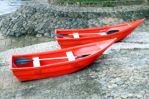 two red rowboat near the river