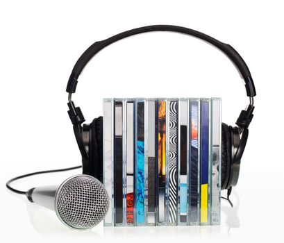 HI-Fi headphones on stack of CDs with microphone on white background