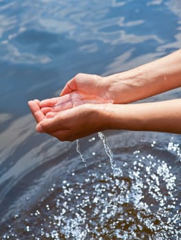 Water pouring out of a young woman's hands