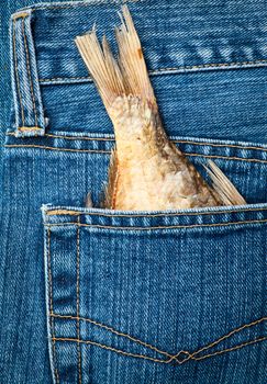 Blue jeans pocket with dried fish tail