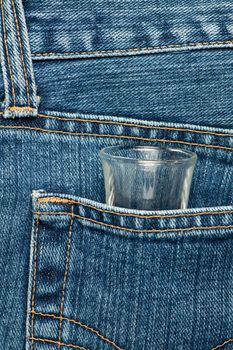 Blue jeans pocket with a shot glass