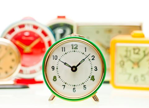 Vintage mechanical wind-up alarm clocks on white background, shallow focus