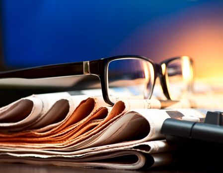 Glasses on stack of newspapers, very shallow focus