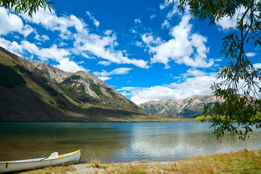 Touring canoe on a mountain lake shoreline