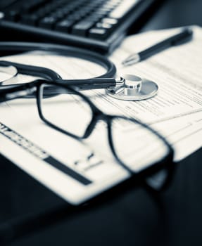 Stethoscope on a prescription form with glasses pen and keyboard, very shallow DOF