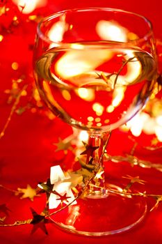 Glass of white wine with star shaped tinsel and lights, very shallow DOF