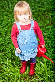 Little girl holding red watering can