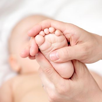 Mother massaging her child's foot, shallow focus