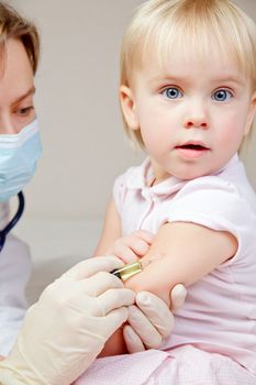 Doctor giving a child an intramuscular injection in arm