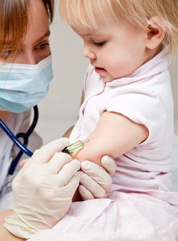 Doctor giving a child an intramuscular injection in arm