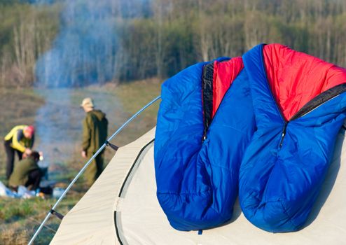 Two sleeping bags drying on camping tent